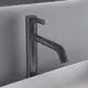 Schwarze Waschtischarmatur von Ideal Standard mit seitlichem Hebel und abgerundetem Auslauf, montiert in einem weißen Waschbecken.